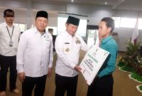 Pj Gubernur NTB, Hassanudin menyerahkan bantuan secara simbolis kepada siswa berprestasi  kurang mampu. Foto Dedi Shd.