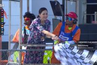 Artis Maia Estianty saat mengibarkan bendera Finish menggunakan kalung Id Card VIP. Sabtu (29/09/2024). Foto: (MotoGP)