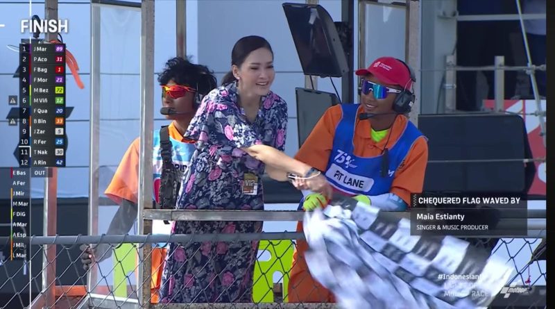 Artis Maia Estianty saat mengibarkan bendera Finish menggunakan kalung Id Card VIP. Sabtu (29/09/2024). Foto: (MotoGP)