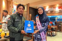 Winner Miss Hijab NTB 2024 dan Runner Up 3 Miss Hijab Indonesia 2024 Baiq Clarisa Julia Putri Yetasya, menyerahkan dokumen keberangkatan peserta magang LPKS Doryouku atas nama Junaedi. Selasa (19/11/2024). Foto: (Mamiq Sahaya).