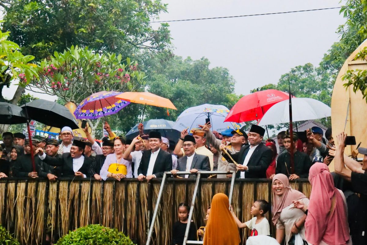 Dengan memanfaatkan payung, warga menyaksikan prosesi budaya perang Topat di pura - kemaliq Lingsar Minggu 15 Desember 2024 (DSHD )