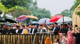 Dengan memanfaatkan payung, warga menyaksikan prosesi budaya perang Topat di pura - kemaliq Lingsar Minggu 15 Desember 2024 (DSHD )