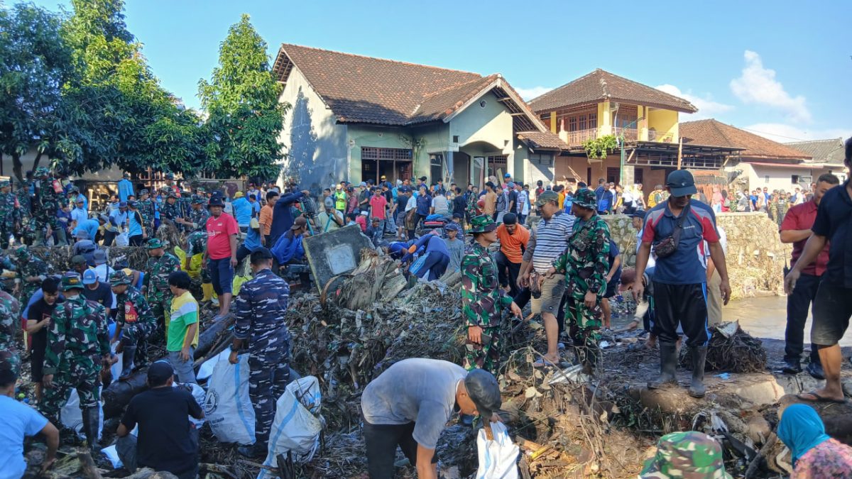 TNI dan Warga bahu membahu membersihkan sisa-sisa sampah pasca banjir yang melanda Minggu 6 Juli 2025. Foto (Doc.Ist).