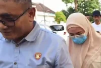 Penyidik Polresta Mataram menggiring Rabiatul Adawiyah usai menjalani pemeriksaan sebagai tersangka kasus korupsi pengadaan masker COVID-19 tahun anggaran 2020, Sabtu (2/8/2025).