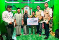 Manager PLN ULP Pringgabaya, Agus Dwi Windya Saputra (dua dari kanan) menyerahkan secara simbolis bantuan kepada 36 anak yatim piatu di Lembaga Kesejahteraan Sosial Anak (LKSA) Raudlatul Athfal NW Karang Kapitan, Kecamatan Pringgabaya, Kabupaten Lombok Timur. Foto (Doc.PLN UIW NTB)