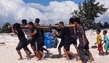 Petugas PLN Unit Layanan Pembangkit Listrik (ULPL) Waingapu bersama warga bergotong-royong mengangkut peralatan pemeliharaan pembangkit listrik setibanya di Pulau Salura, Sumba Timur, Nusa Tenggara Timur. Seluruh material dipindahkan secara manual dari bibir pantai menuju lokasi pembangkit karena keterbatasan akses transportasi. (PLN Dwipantara)