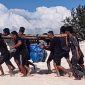 Petugas PLN Unit Layanan Pembangkit Listrik (ULPL) Waingapu bersama warga bergotong-royong mengangkut peralatan pemeliharaan pembangkit listrik setibanya di Pulau Salura, Sumba Timur, Nusa Tenggara Timur. Seluruh material dipindahkan secara manual dari bibir pantai menuju lokasi pembangkit karena keterbatasan akses transportasi. (PLN Dwipantara)